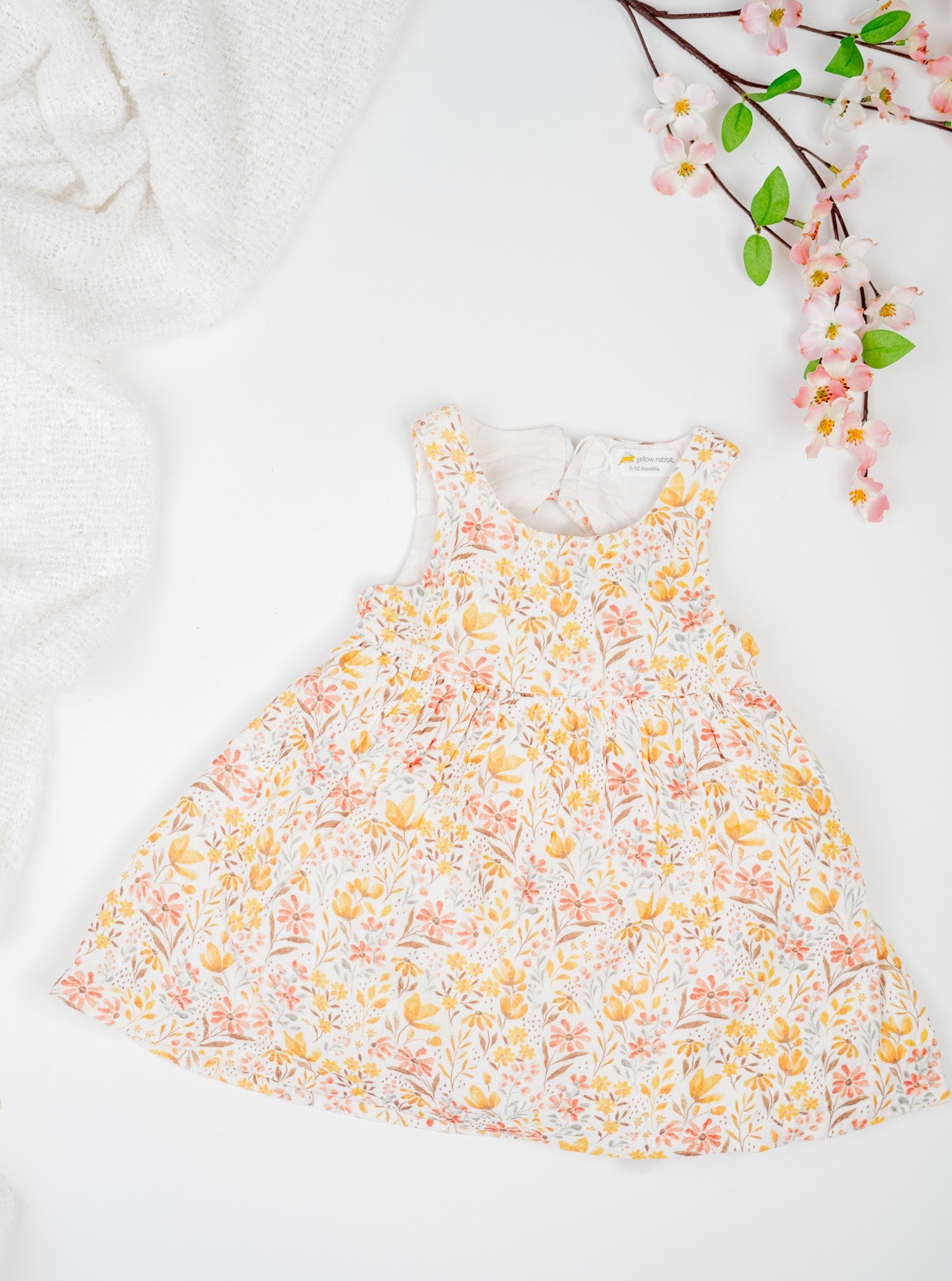 Golden Meadow Dress for girl's in soft yellow organic cotton, featuring a delicate floral print inn earthy tones, sleeveless and a breezy A-line silhouette.