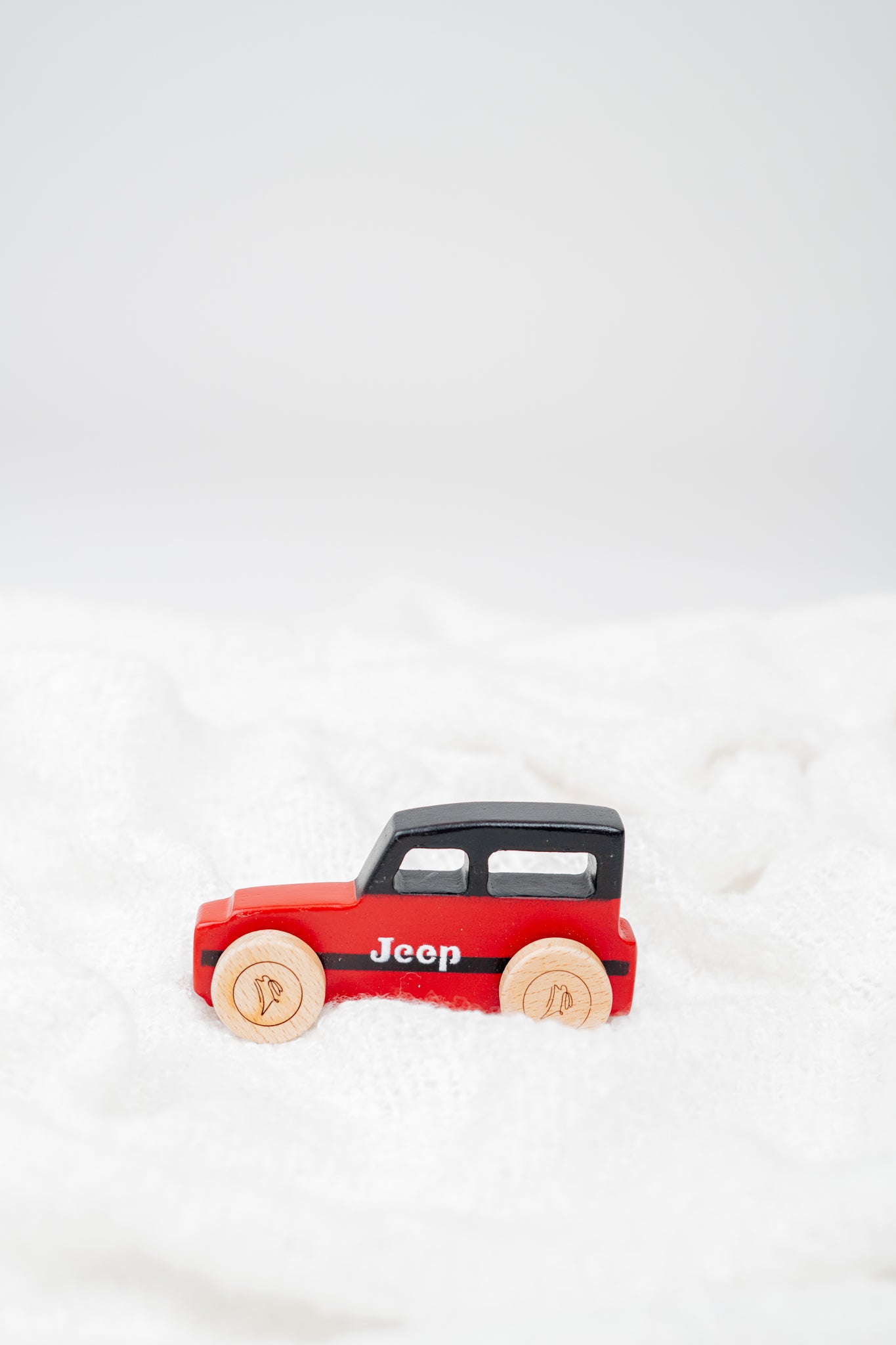 Wooden push-pull toy modeled after a vintage jeep with wheels for toddler-safe play.