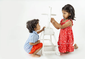 Girl with red nightingale shirred dress, and boy with light blue shirt and red chino shorts