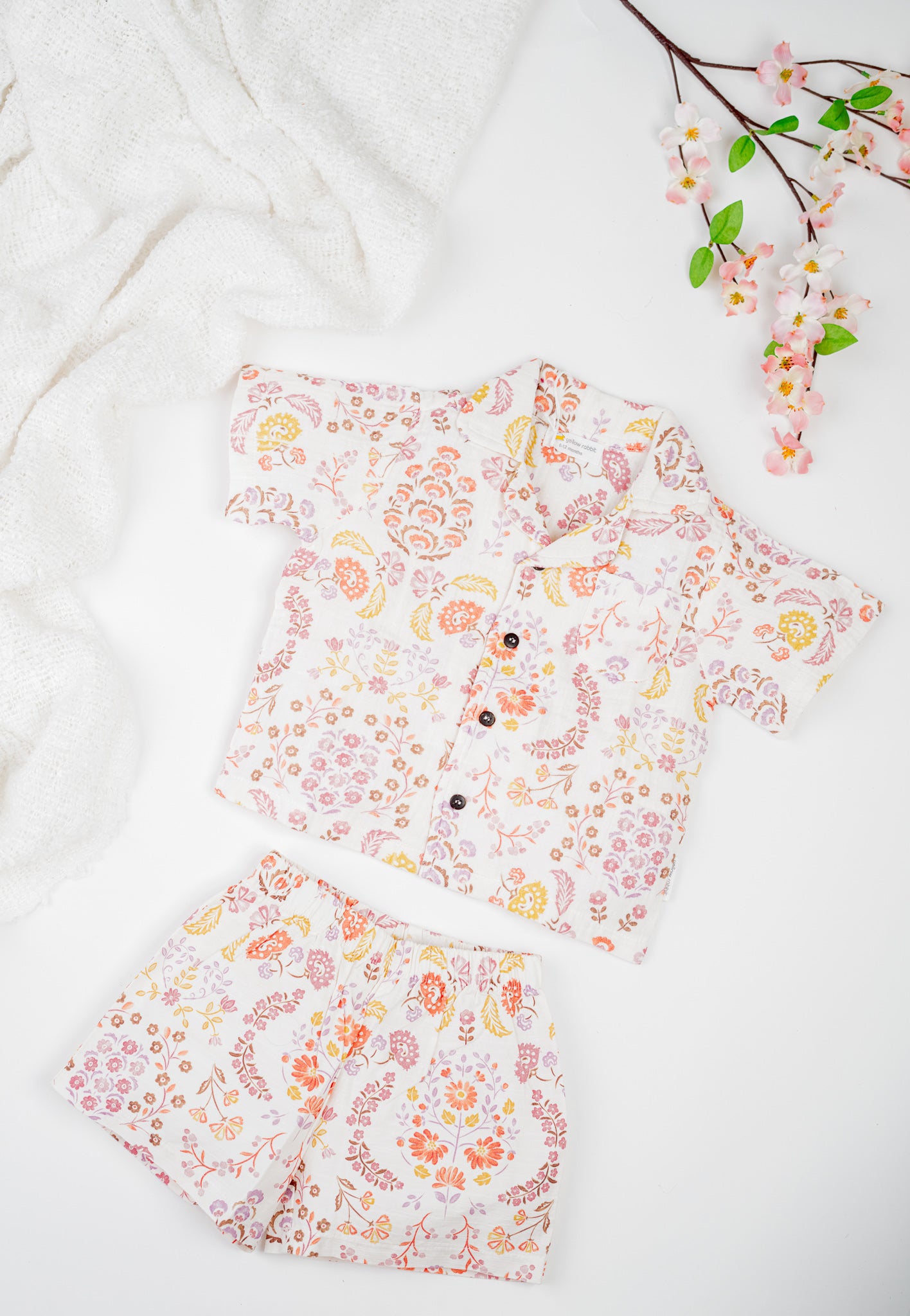 Organic cotton co-ord set with boteh print in earthy red, orange and yellow tones, collared shirt and matching shorts.