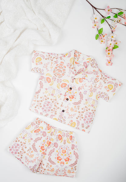 Organic cotton co-ord set with boteh print in earthy red, orange and yellow tones, collared shirt and matching shorts.