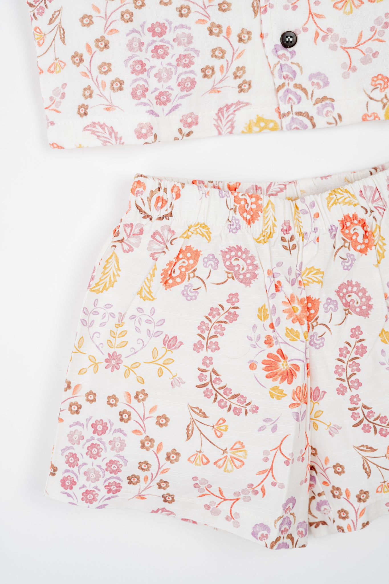 Organic cotton co-ord set with boteh print in earthy red, orange and yellow tones, collared shirt and matching shorts.