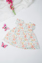 Baby girl's Christmas dress with festive eucalyptus and red floral print, featuring short sleeves and a gathered wait, made from lightweight organic cotton- perfect for holiday celebrations