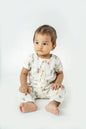 Organic cotton toddler playsuit featuring whimsical garden vegetables on a soft white background - perfect for cozy, eco-friendly everyday wear.