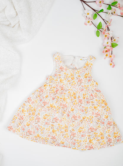 Golden Meadow Dress for girl's in soft yellow organic cotton, featuring a delicate floral print inn earthy tones, sleeveless and a breezy A-line silhouette.