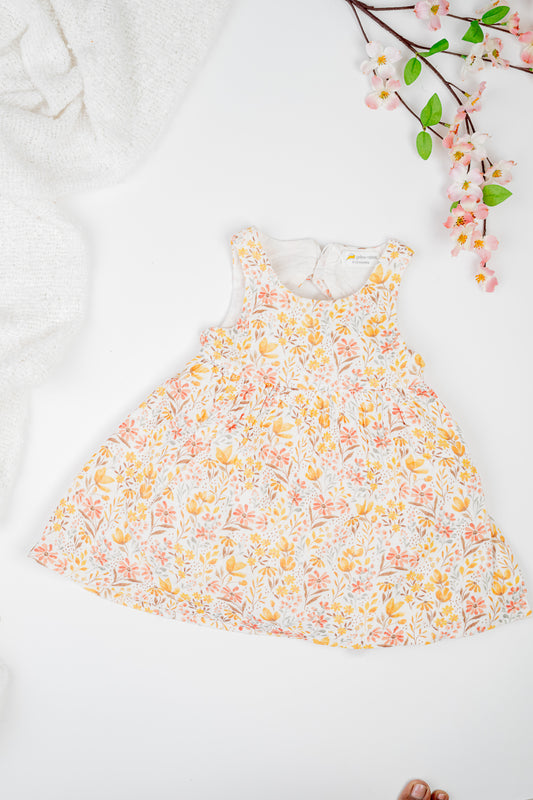Golden Meadow Dress for girl's in soft yellow organic cotton, featuring a delicate floral print inn earthy tones, sleeveless and a breezy A-line silhouette.