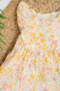 Golden Meadow infant girl's dress in soft yellow organic cotton, featuring an all-over floral print, flutter sleeves and gentle gathers for a breezy summer fit.