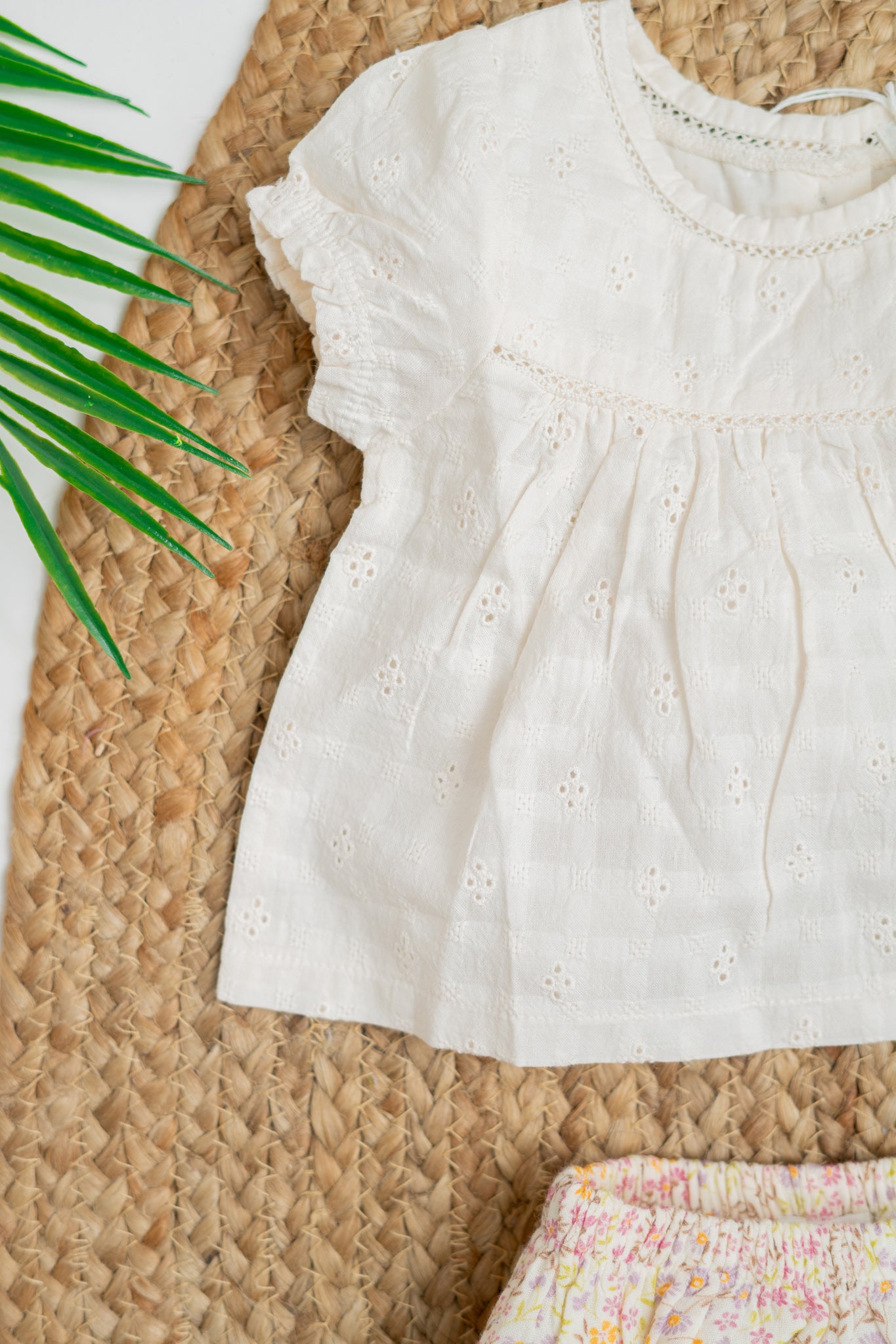 White Hakoba cotton jhabla top with delicate embroidery and puff sleeves, paired with floral print bloomers in pastel pink and yellow, perfect for infant girls' summer wear.
