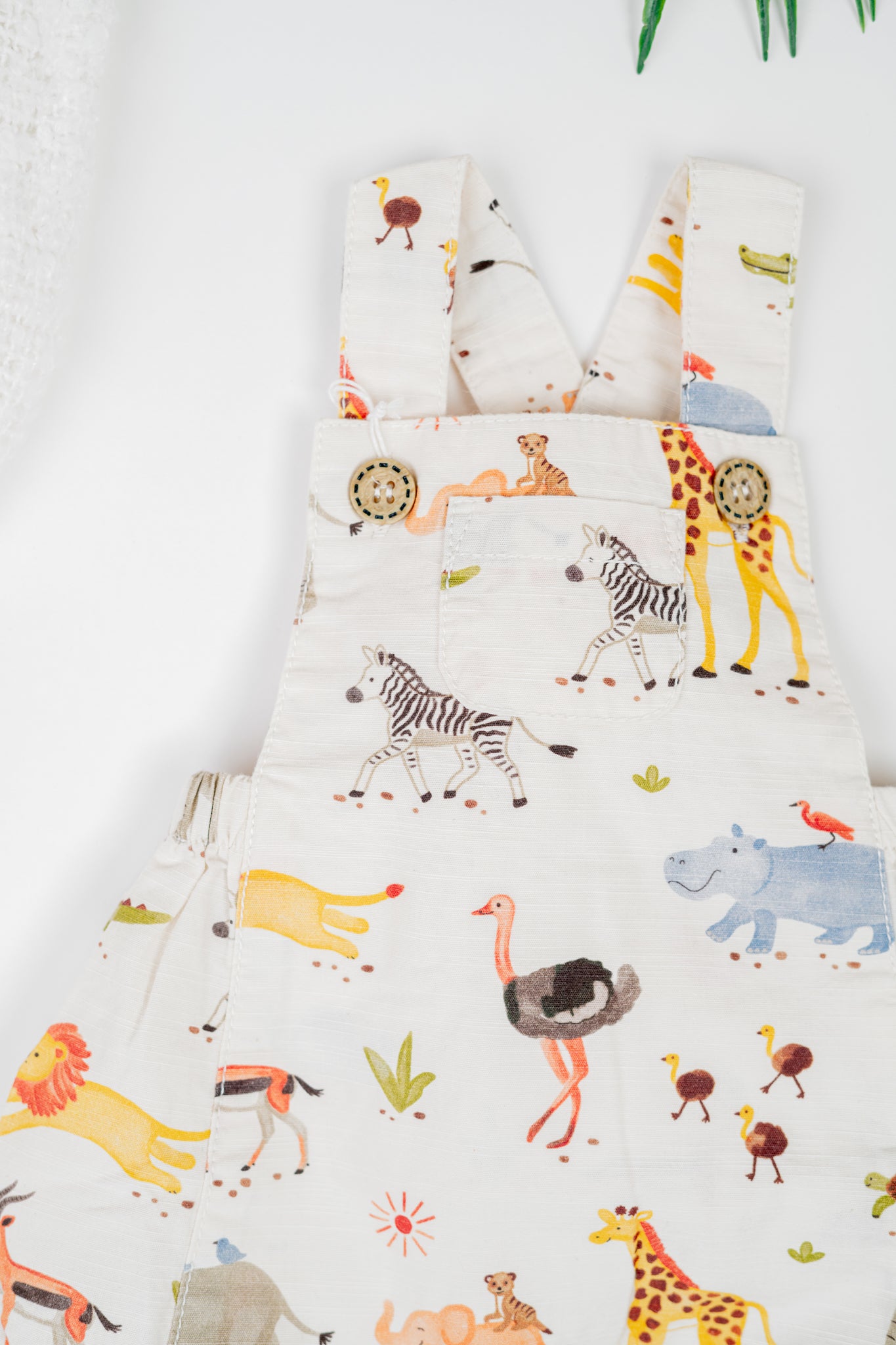 Kids' organic cotton overalls with water colour safari animal print, adjustable strap, and snap buttons for easy changes.