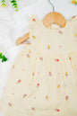 Infant girl's dress featuring a vibrant yellow hue with delicate tulip embroidery