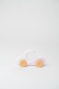 Minimalist wooden toy in the shape of a white electric bike, designed for toddlers to push and pull.