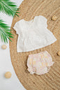 White Hakoba cotton jhabla top with delicate embroidery and puff sleeves, paired with floral print bloomers in pastel pink and yellow, perfect for infant girls' summer wear.