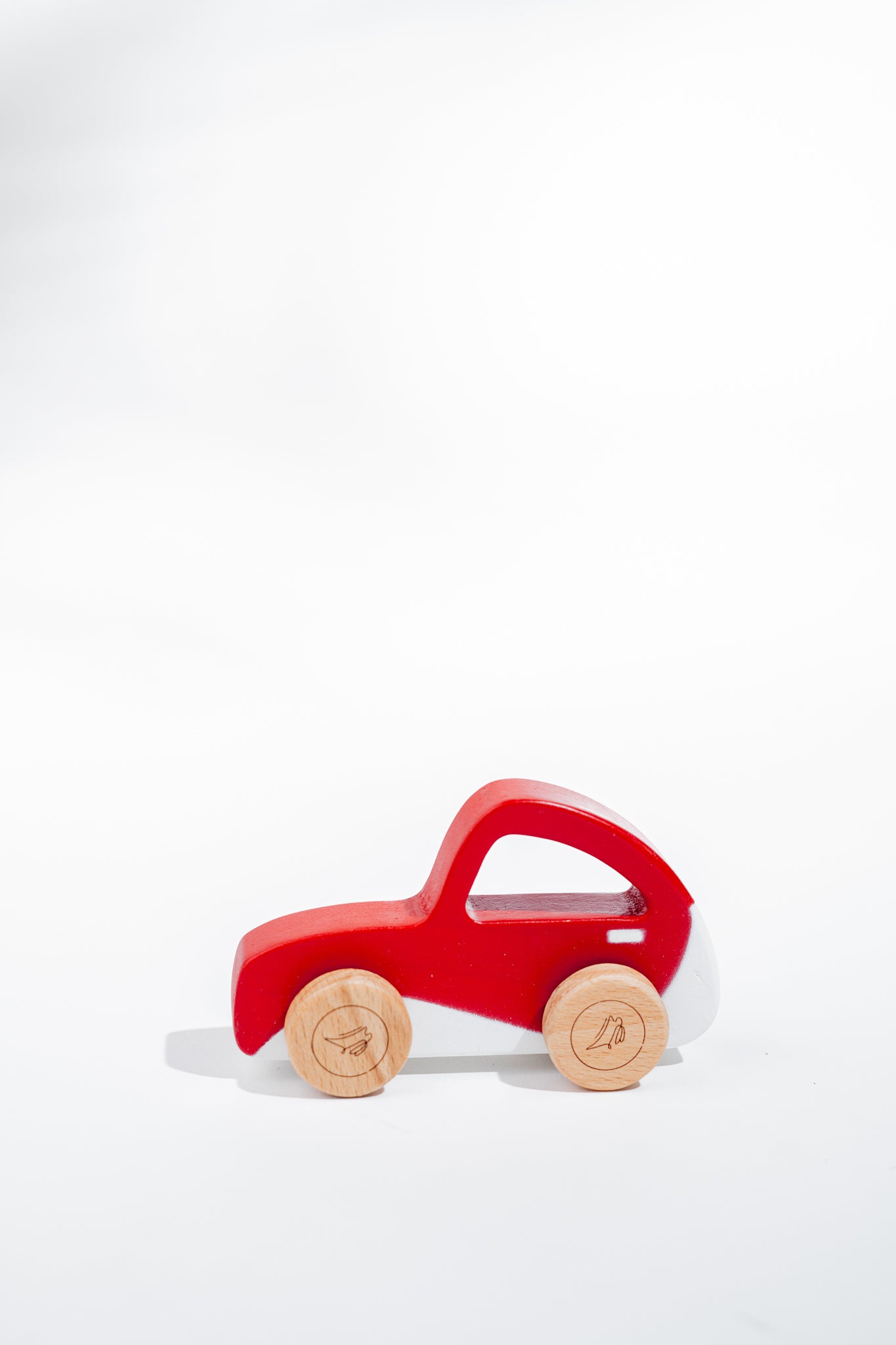 Sustainably made red wooden beetle toy with smooth wheels for pushing or pulling - toddler safe design.